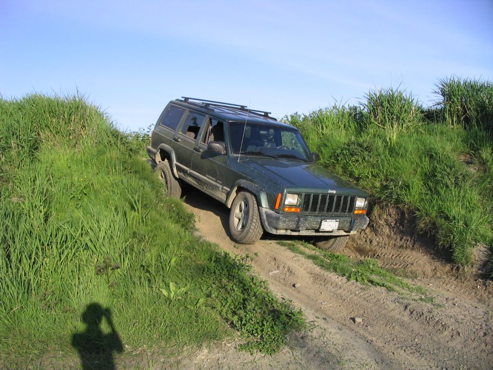 Green 2000 Jeep Cherokee on a dirt path