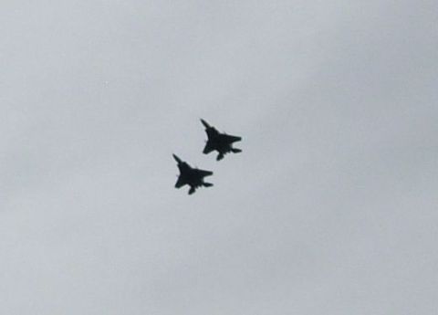 1995 Ford Bronco - Two fighter jets are captured in mid-flight against a hazy sky, with a Supermotors watermark visible at the bottom right.