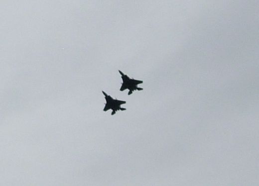 Two fighter jets in formation against a cloudy sky