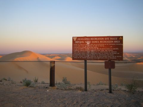 1968 Ford Mustang - A sign details the rules for the Imperial Sand Dunes Recreation Area as the sun sets over the desert landscape.