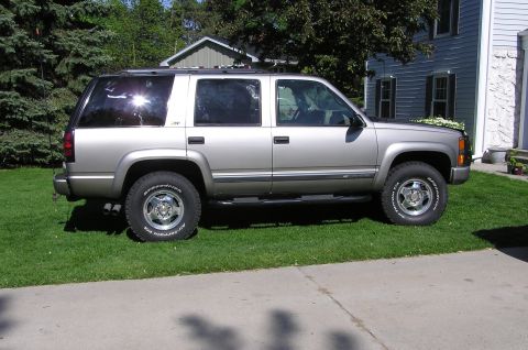 2000 Chevrolet Tahoe - This SUV is parked on the grass in front of a residential house on a sunny day.