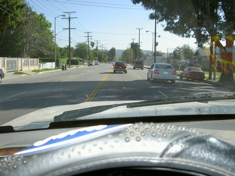 Driver's view through the windshield down a suburban street with traffic ahead