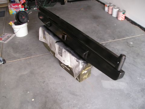 1996 Ford Bronco - A black bumper is shown in a garage setting, resting on ammunition cans and newspaper.