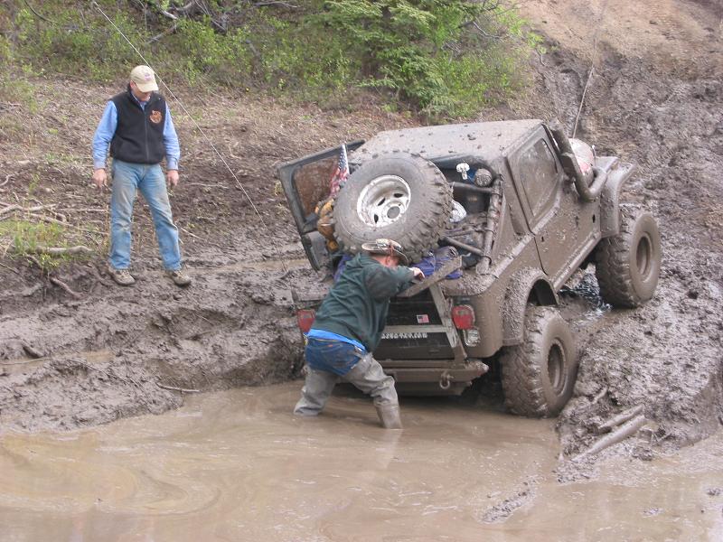 Wayne (From Arctic offroad) Getting at Greg's tree saver strap to get him out of the pit.