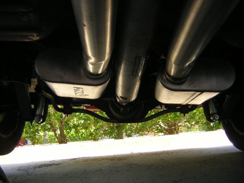1992 Ford Crown Victoria - Underside view of a dual exhaust system with two chrome-tip mufflers and a crossover pipe mounted beneath a vehicle.
