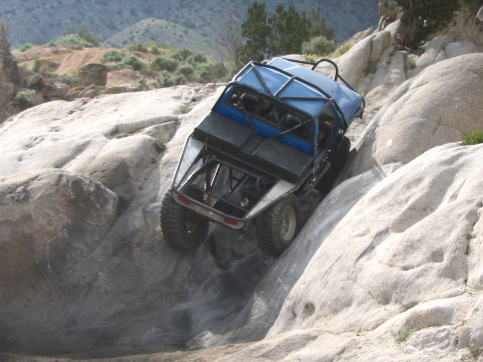 Blue tube-chassis rock buggy climbing a large rock face