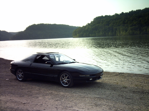 Black 1995 Ford Probe with sunroof parked by a lake