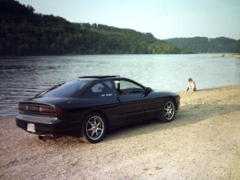 1995 Ford Probe - Black 1995 Ford Probe sits by the water on a sunny day.