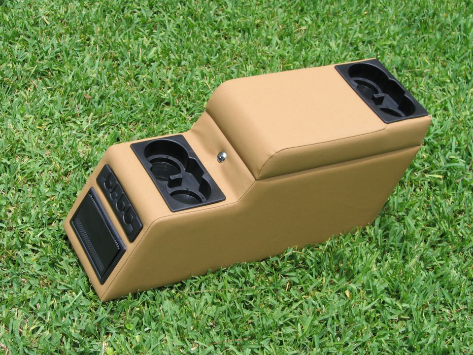 tan center console with two sets of cup holders, a lock, and buttons
