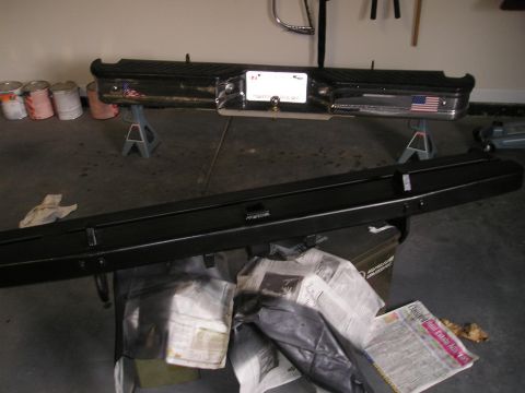 1996 Ford Bronco - A rear bumper with a license plate and an American flag sticker is displayed on jack stands.