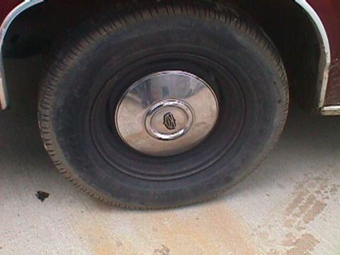 1994 Ford Crown Victoria - Close-up of a vehicle's wheel and tire, showing a chrome hubcap with a central emblem.