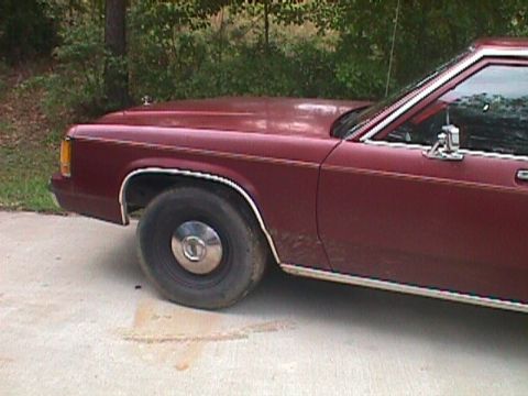1994 Ford Crown Victoria - Side view of a maroon sedan with chrome trim details.