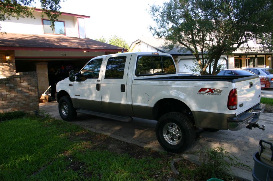 White and brown 2004 Ford F-350 pickup truck parked in driveway, FX4 badging visible on rear fender