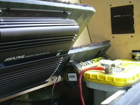 1991 Ford Festiva - Car audio equipment, including an Alpine amplifier and a yellow battery, is installed in a vehicle's interior.