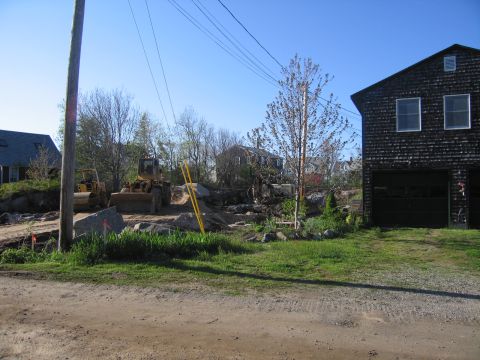 1991 Ford LTD Crown Victoria - Construction equipment is present at a site with a large wooden building and residential homes in the background.