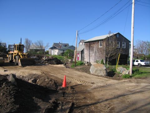 1991 Ford LTD Crown Victoria - A yellow front loader is parked on a dirt construction site, with a white sedan visible in the distance.
