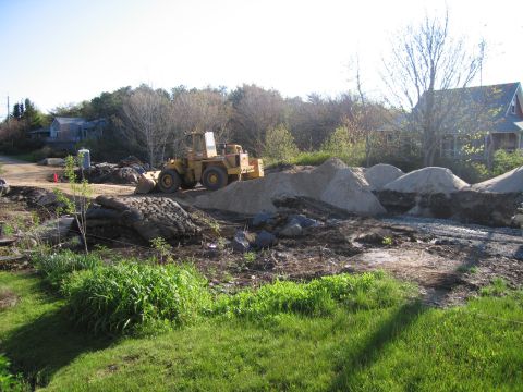 1991 Ford LTD Crown Victoria - A yellow wheel loader is visible at a construction site with various piles of sand and dirt.