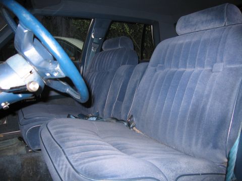1991 Ford LTD Crown Victoria - The interior of the car features plush blue velour seating and a matching blue steering wheel.