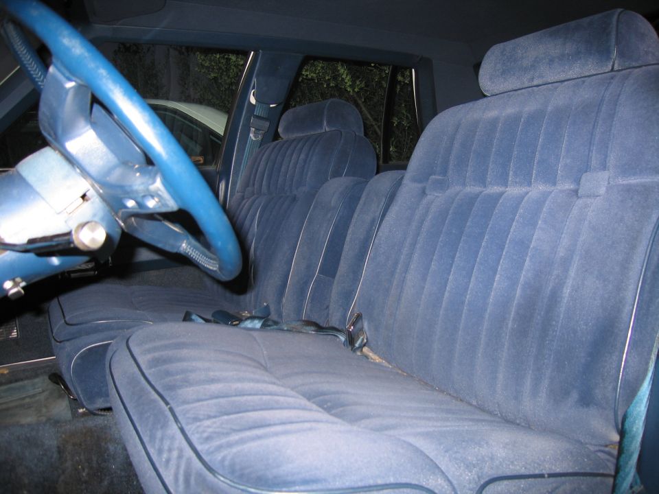 Interior shot of a car with blue velour seats and a blue steering wheel