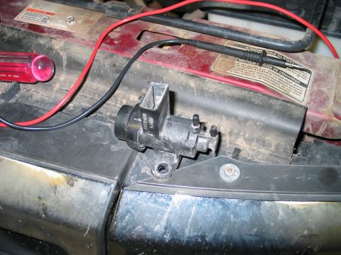1995 Ford Bronco - A close-up view of an engine component with electrical connections and a tool nearby.