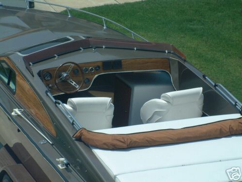 Boat cockpit with wood dash, chrome steering wheel, white seats and brown bolster