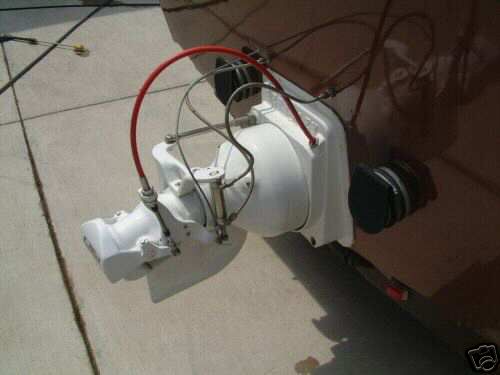 White jet drive unit on transom of tan boat with red hose