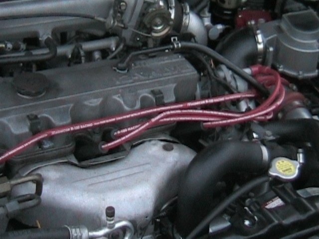 Transverse four-cylinder engine with red Magnecor racing plug wires
