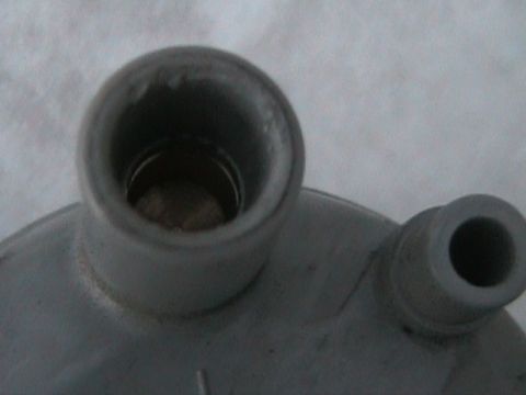 1989 Mazda MX-6 - A close-up view of a metal vehicle component, showing two distinct openings for hoses or connections.