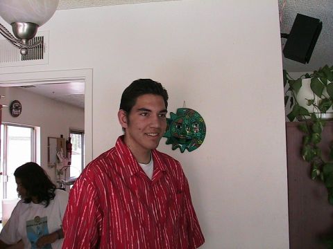1993 Ford Taurus - A young man smiles while standing indoors, with another person visible in the background.