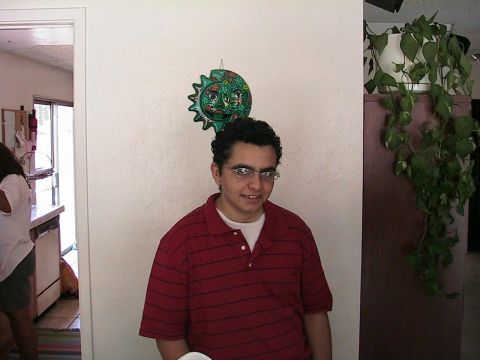 1993 Ford Taurus - A person stands indoors in front of a wall decorated with a sun and moon mask.