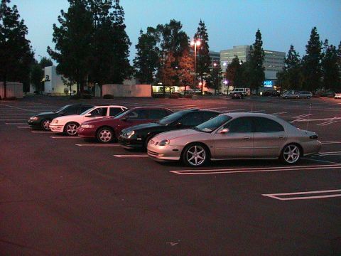 1993 Ford Taurus - A row of sedans are parked in a lot at dusk, with the closest vehicle appearing to be a 2000 Ford Taurus.