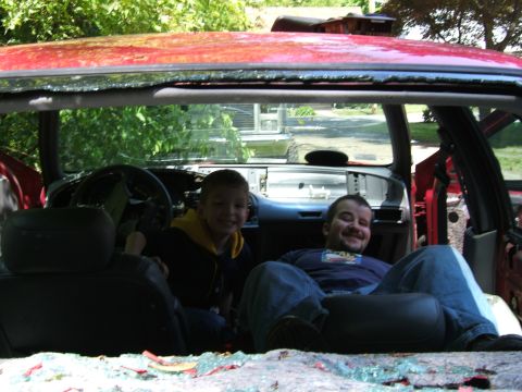 1998 Ford Taurus - Two people are sitting inside a car that appears to be undergoing some form of modification or repair.