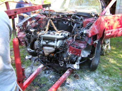 1998 Ford Taurus - Engine removal in progress on a damaged red car.