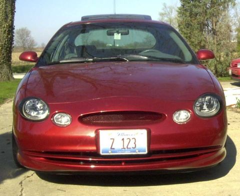 1997 Ford Taurus - Front view of a red sedan with a sunroof and a license plate reading Z 123.