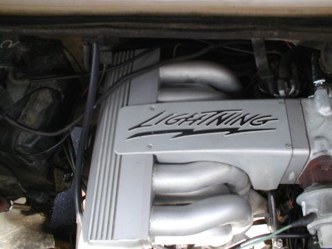1979 Ford Bronco - Close-up of an engine component with "LIGHTNING" branding, showing exhaust manifolds and wiring.