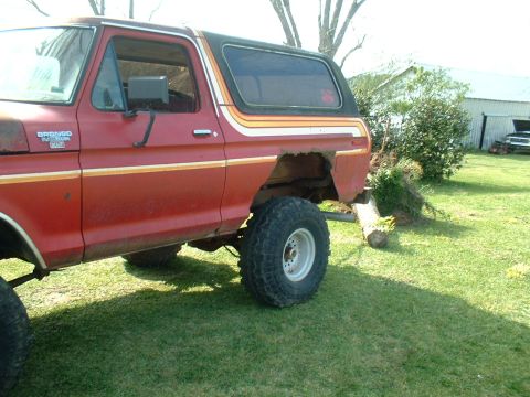 1978 Ford Bronco - A red 1978 Ford Bronco is parked on a grassy area with a barn in the background.