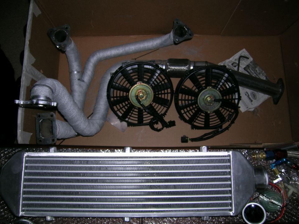 Turbocharger exhaust manifold with heat wrap, two electric fans, and an intercooler
