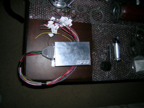1994 Ford Probe - Engine control unit and fuel pump parts laid out on a table.