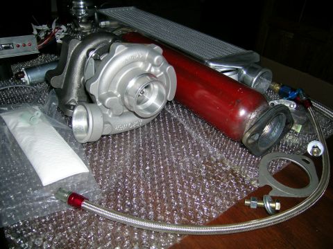 1994 Ford Probe - A collection of aftermarket turbocharger components, including a turbo, intercooler, and associated piping, are displayed.