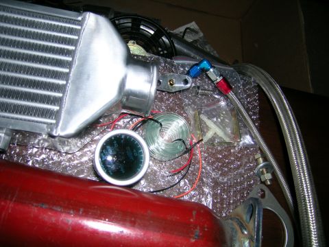 1994 Ford Probe - Close-up of an intercooler and a gauge, with a red pipe in the foreground.