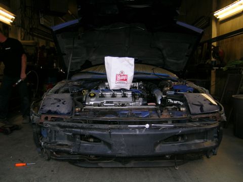 1994 Ford Probe - A car's engine bay is visible with a Wendy's bag placed on top of the engine components.