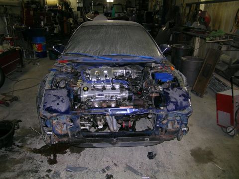 1994 Ford Probe - Front view of a blue car in a workshop, with the hood open and the engine compartment fully visible. The car appears to be undergoing repai…