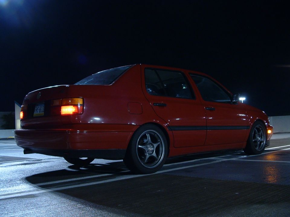 Red 1994 Volkswagen Jetta parked at night, viewed from the rear quarter
