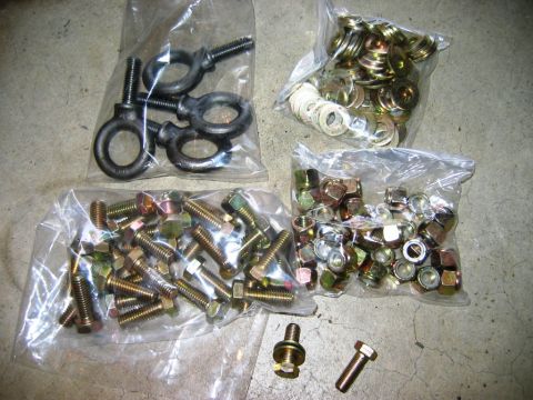 1985 Ford Bronco - This photo shows various vehicle hardware, including eye bolts, nuts, bolts, and washers, packaged in plastic bags.