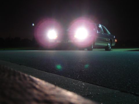 1988 Ford Crown Victoria LTD - Front view of a 1988 Ford Crown Victoria LTD at night, headlights illuminated.