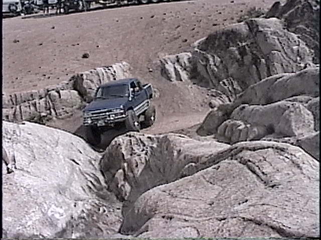 Blue 1997 Chevrolet C/K Pickup truck off-roading over rocks