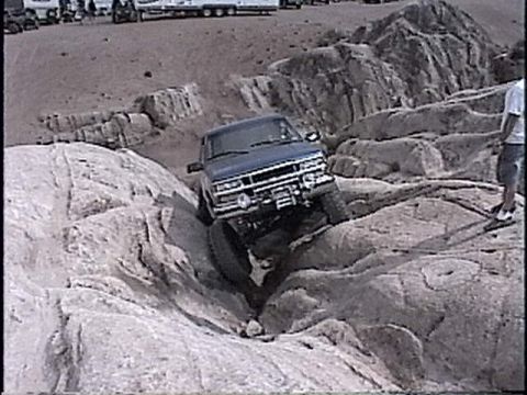 1997 Chevrolet C/K Pickup - A blue 1997 Chevrolet C/K Pickup truck maneuvers through a challenging rocky off-road course.