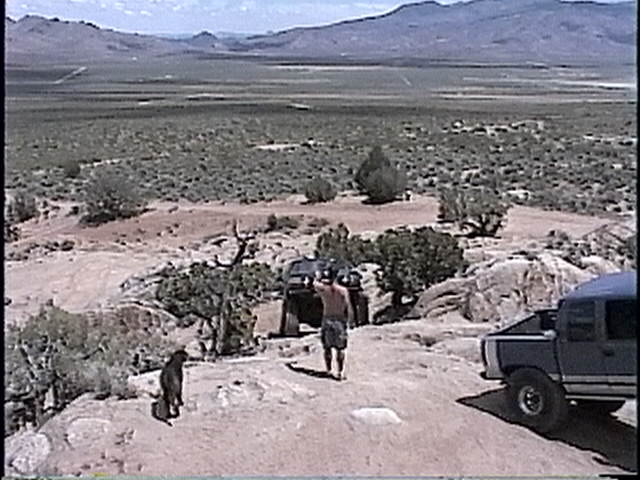 1997 Chevrolet C/K Pickup parked in desert with another truck and person