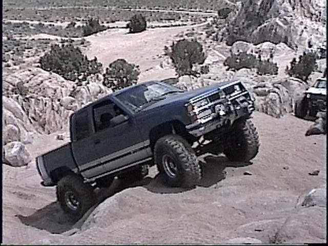 1997 Chevrolet C/K Pickup climbing rocky terrain, another vehicle visible in background