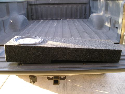 1999 Ford F-150 - A subwoofer box is placed in the bed of a pickup truck, which is equipped with a trailer hitch.
